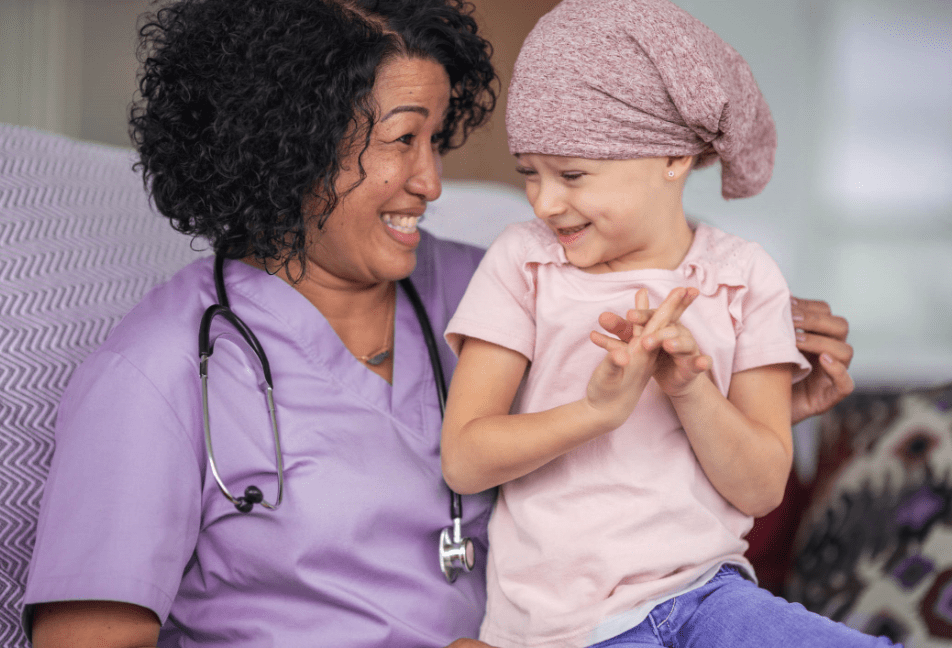 A smiling nurse carying a child.